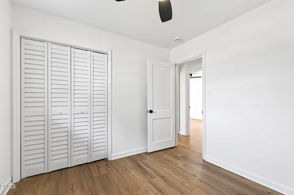 an empty room with wooden floor and white walls