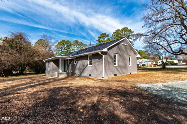 a front view of house with yard and trees in the background