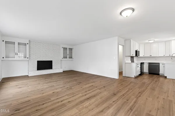 a view of empty room with wooden floor and fireplace