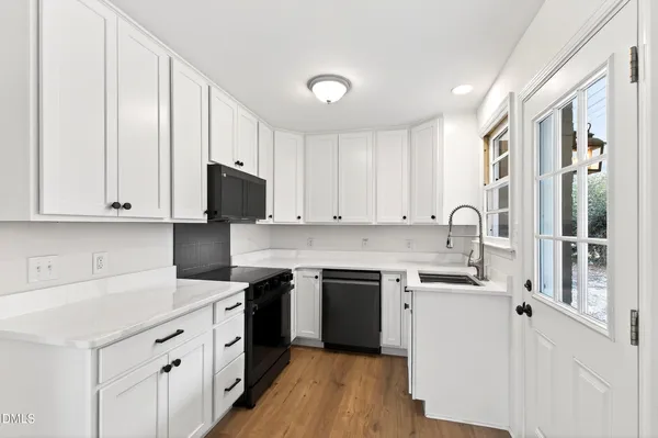 a kitchen with a sink stove and white cabinets