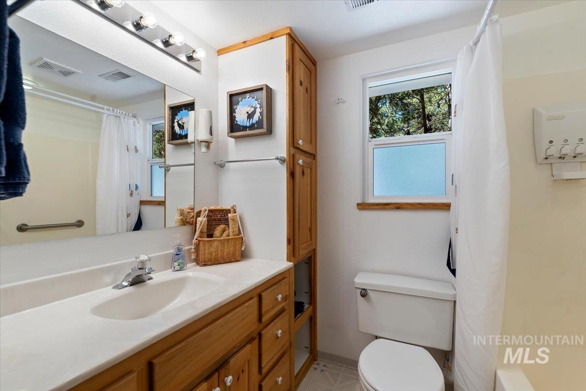 44 Ridgeview Drive Cascade, ID 83611 - Photo 18 of 29 Bathroom with vanity, shower / bath combination with curtain, and plenty of natural light