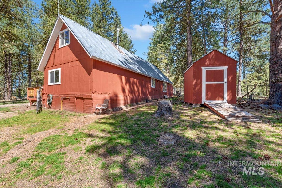 44 Ridgeview Drive Cascade, ID 83611 - Photo 26 of 29 View of home's exterior featuring a metal roof, a storage unit, and a lawn