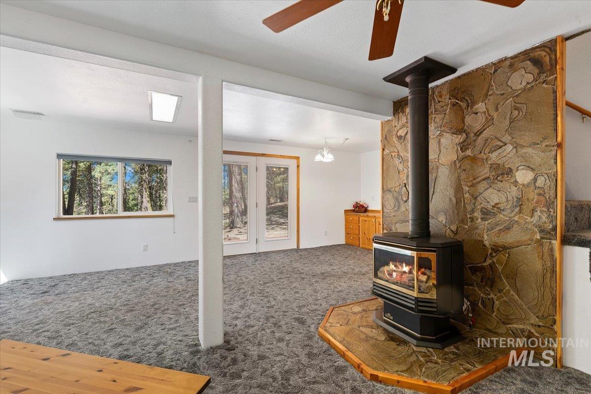 44 Ridgeview Drive Cascade, ID 83611 - Photo 8 of 29 Unfurnished living room with carpet, a wood stove, and ceiling fan