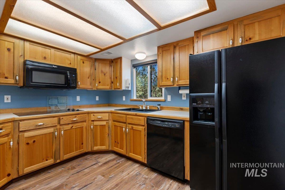 44 Ridgeview Drive Cascade, ID 83611 - Photo 10 of 29 Kitchen with black appliances, light countertops, light wood-style flooring, and wood finish cabinetry