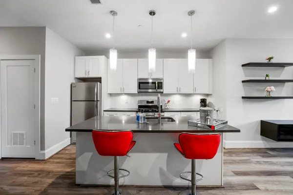 a kitchen with stainless steel appliances granite countertop a refrigerator and a stove top oven