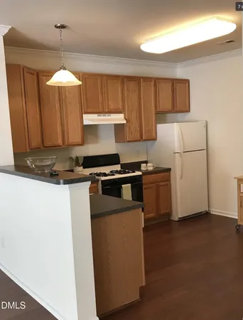 a kitchen with granite countertop a stove a sink and a refrigerator