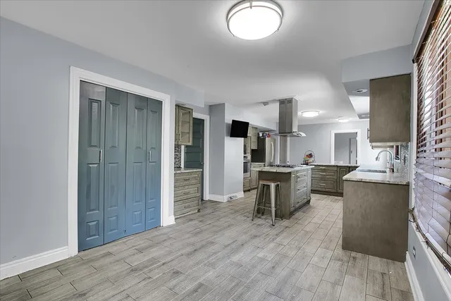 a kitchen with stainless steel appliances a refrigerator and a wooden floor