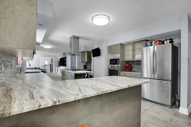 a large kitchen with kitchen island a sink stainless steel appliances and cabinets