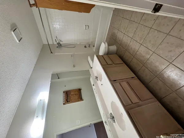 a bathroom with a granite countertop sink a toilet and shower