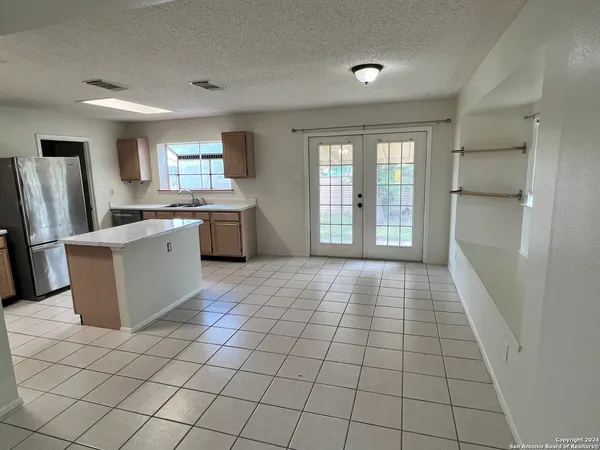 a kitchen with stainless steel appliances a sink a stove a refrigerator a window