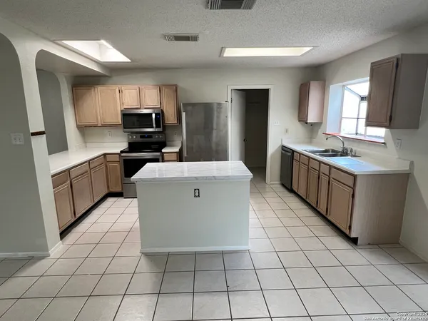 a kitchen with stainless steel appliances a sink stove top oven and cabinets
