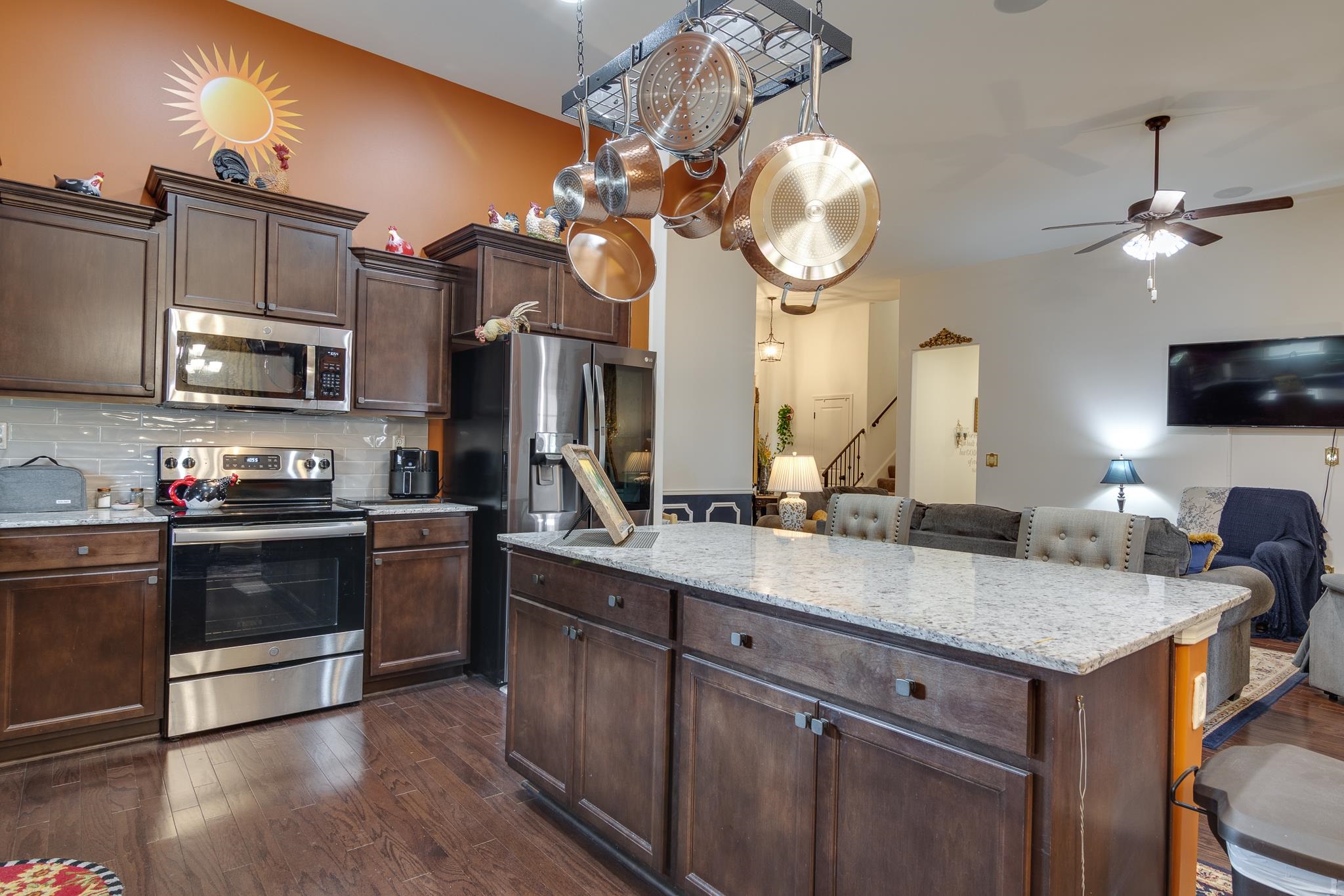 135 Chesnut Rdg Drive Oakland, TN 38060 - Photo 36 of 36 Kitchen featuring dark wood finish cabinets, stainless steel appliances, light stone countertops, a breakfast bar, and open floor plan