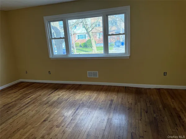 a view of a room with wooden floor and a window
