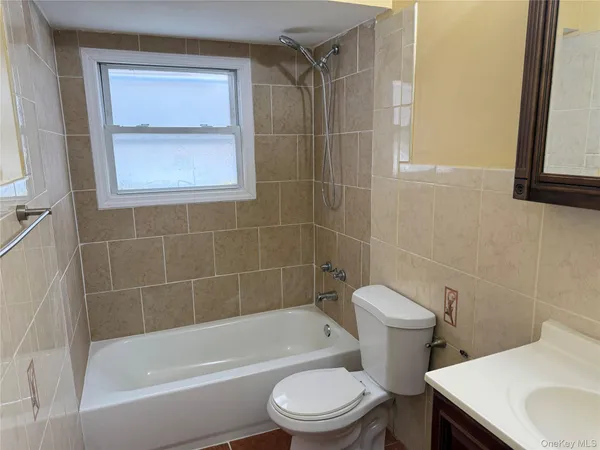 a white toilet and tub sitting next to a bathroom sink