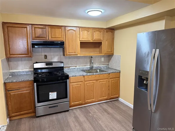 a kitchen with granite countertop wooden cabinets and a stainless steel appliances