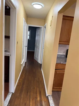 a view of a hallway with wooden floor and staircase