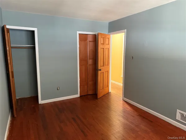 an empty room with wooden floor and closet