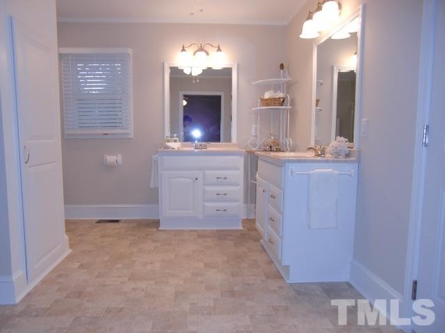 302 Jackson Road Dunn, NC 28334 - Photo 19 of 25 Master Bedroom has a Double Closet, Hardwood Floor, Large Pocket Door to Full Bath with Double Vanities, 5FT Shower with Frameless Glass Doors, Linen Closet, New Fixtures, Vinyl Floor.