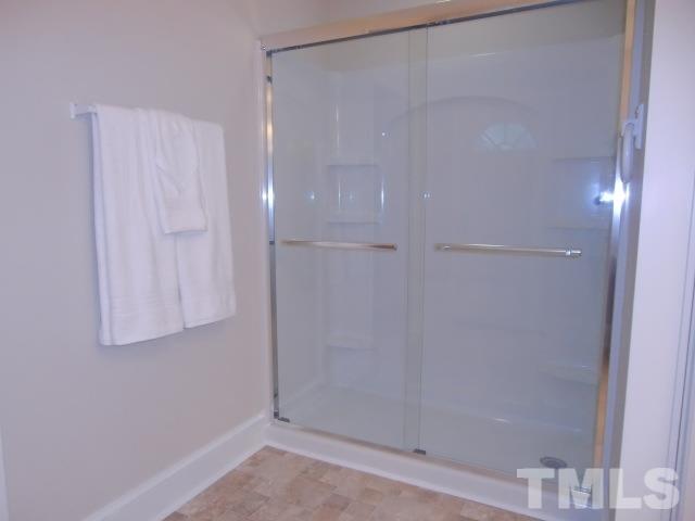 302 Jackson Road Dunn, NC 28334 - Photo 20 of 25 Master Bedroom has a Double Closet, Hardwood Floor, Large Pocket Door to Full Bath with Double Vanities, 5FT Shower with Frameless Glass Doors, Linen Closet, New Fixtures, Vinyl Floor.