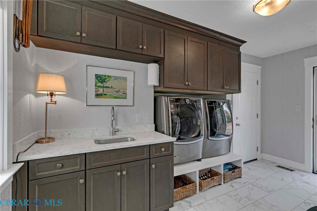 411 Hookemfair Road Cobbs Creek, VA 23035 - Photo 19 of 50 Custom Laundry Room with built in cabinets and a sink. Washer/Dryer elevated giving more storage space