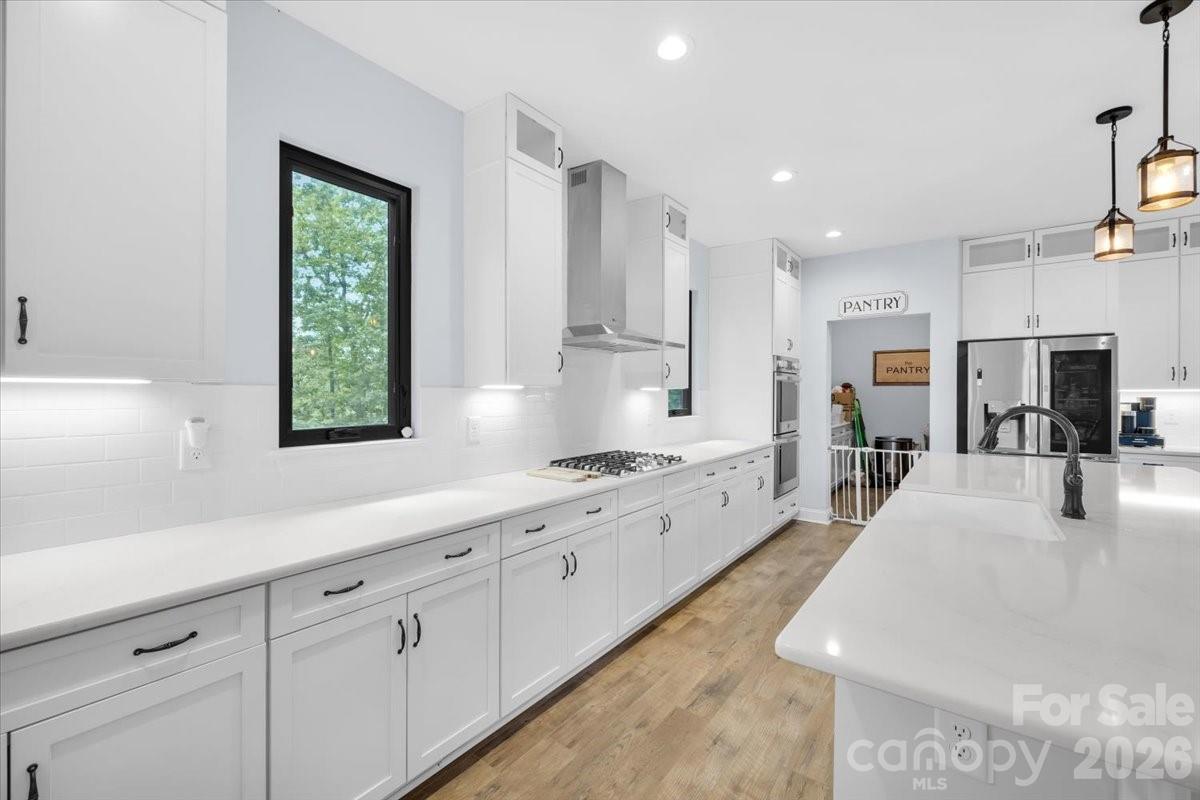 1194 99 Island Road Blacksburg, SC 29702 - Photo 11 of 47 a large white kitchen with stainless steel appliances granite countertop a stove a sink a refrigerator and white cabinets with wooden floor