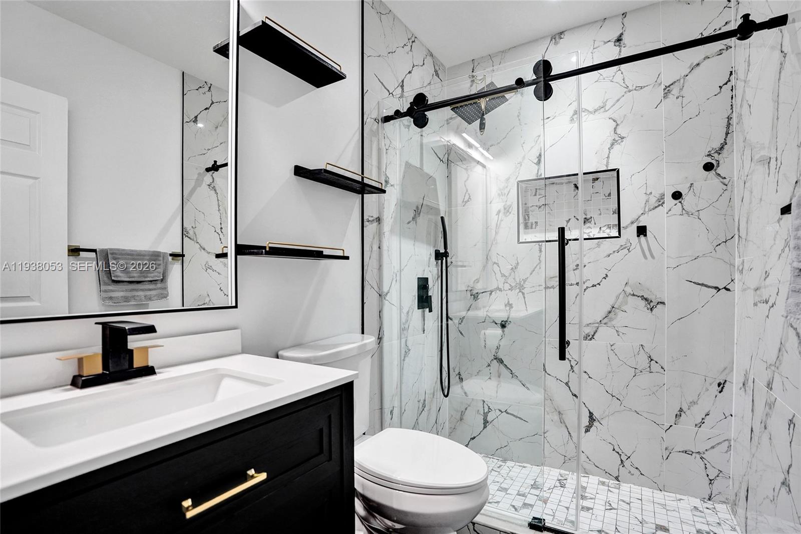 a bathroom with a sink toilet vanity and shower