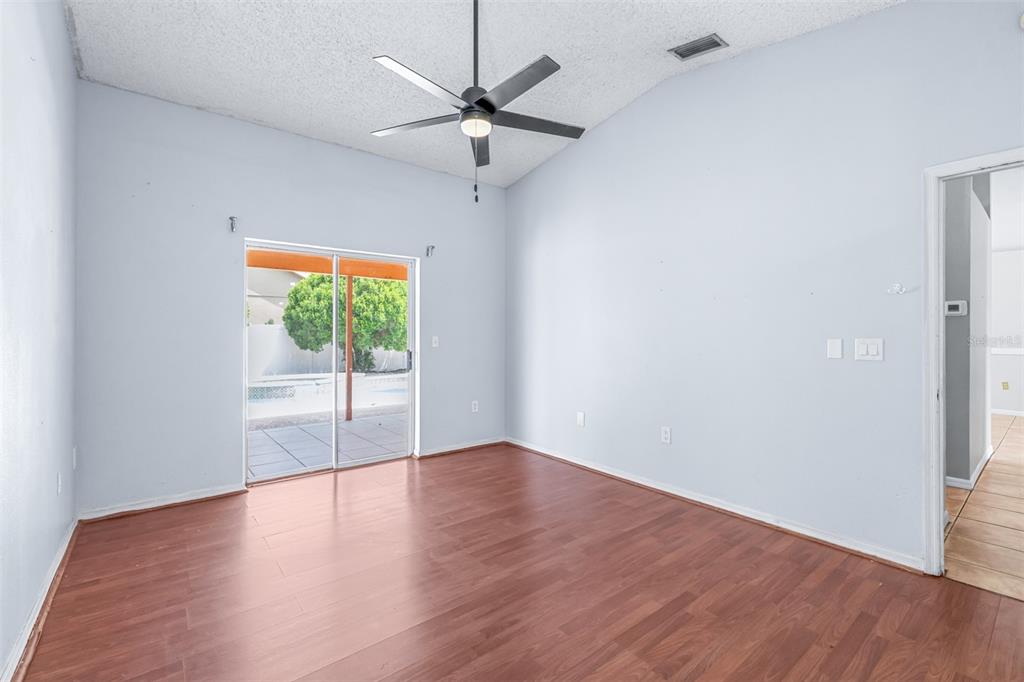 2538 Countryside Pines Drive Clearwater, FL 33761 - Photo 23 of 61 an empty room with wooden floor fan and windows