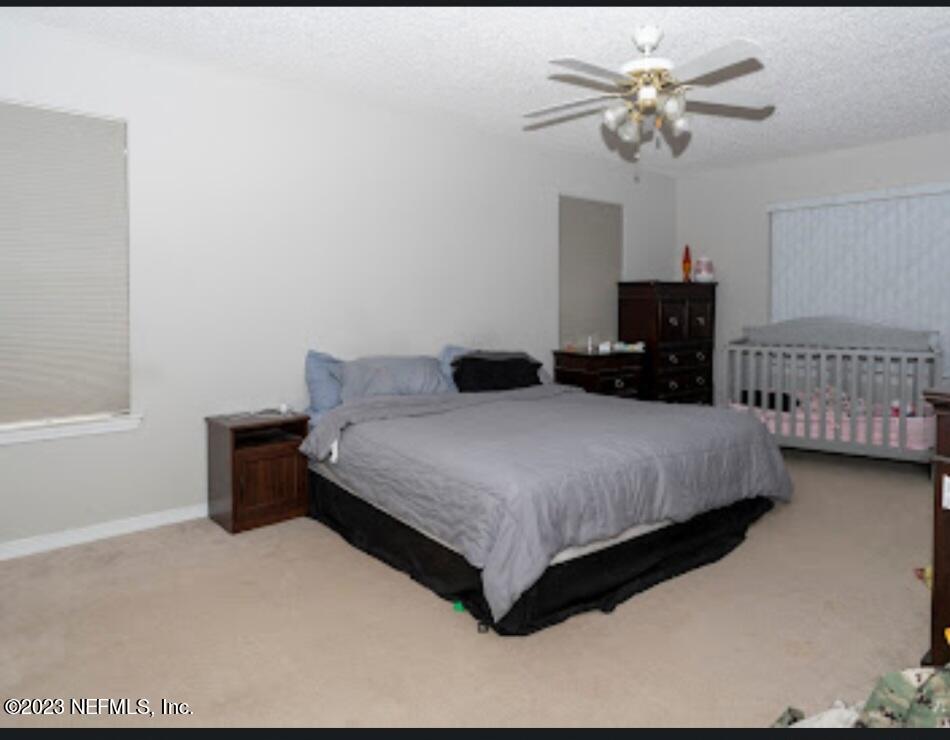2504 Mallory Hills Road Jacksonville, FL 32221 - Photo 13 of 30 a bedroom with a bed chandelier and a window