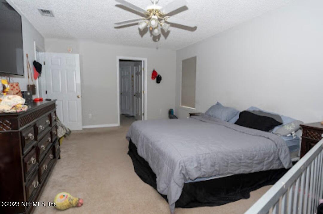 2504 Mallory Hills Road Jacksonville, FL 32221 - Photo 14 of 30 a bedroom with a bed and a flat tv screen on dresser