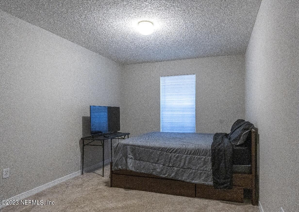 2504 Mallory Hills Road Jacksonville, FL 32221 - Photo 21 of 30 a bedroom with a bed and a night stand