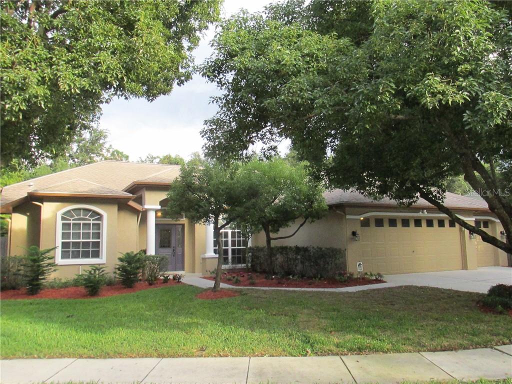 1044 Waybrook Court Lutz, FL 33549 - Photo 1 of 1 a front view of a house with a garden and trees