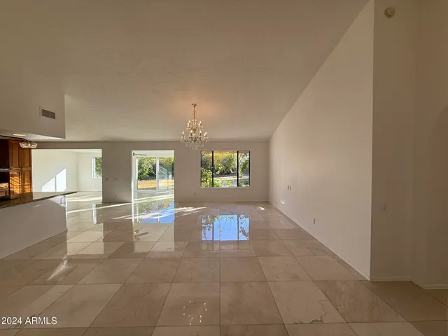 a view of a livingroom with furniture cabinet and chandelier