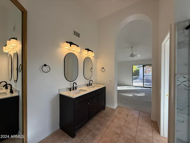 a bathroom with a tub shower and mirror