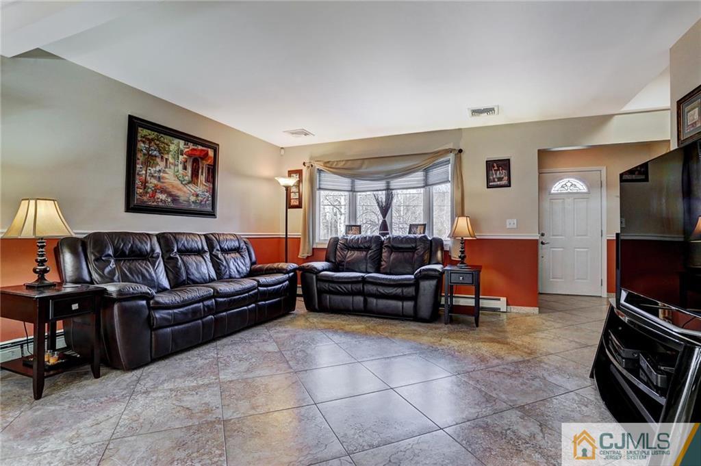 26 Pleasant Valley Road Old Bridge, NJ 08857 - Photo 11 of 25 a living room with furniture a flat screen tv and a fireplace