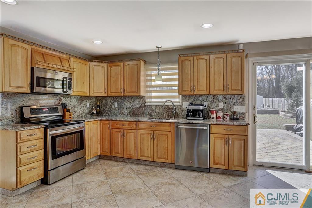 26 Pleasant Valley Road Old Bridge, NJ 08857 - Photo 4 of 25 a kitchen with stainless steel appliances granite countertop a stove a sink and a microwave