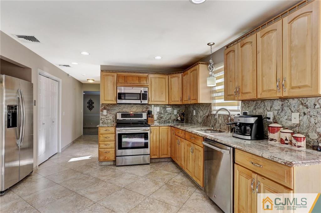 26 Pleasant Valley Road Old Bridge, NJ 08857 - Photo 5 of 25 a kitchen with stainless steel appliances granite countertop a refrigerator and a stove top oven