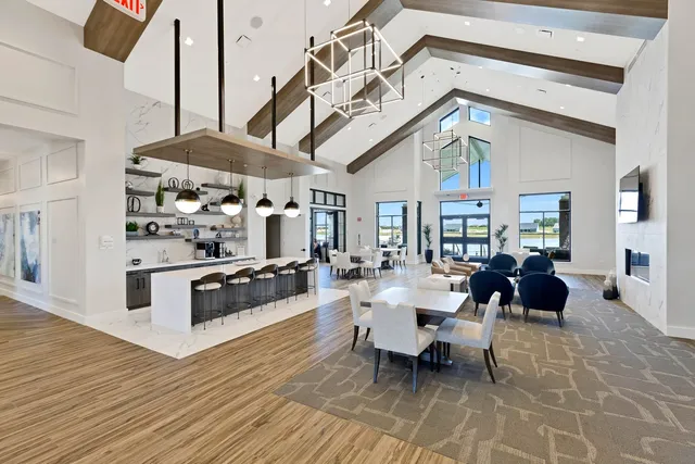 a dining hall with couches a flat tv screen and a dining table with wooden floor