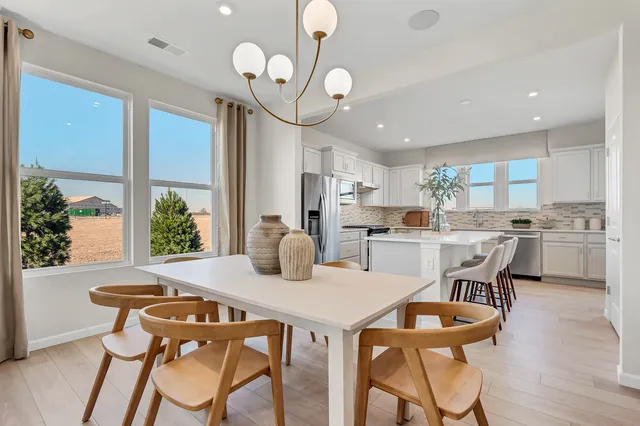 a kitchen with a dining table chairs sink and refrigerator