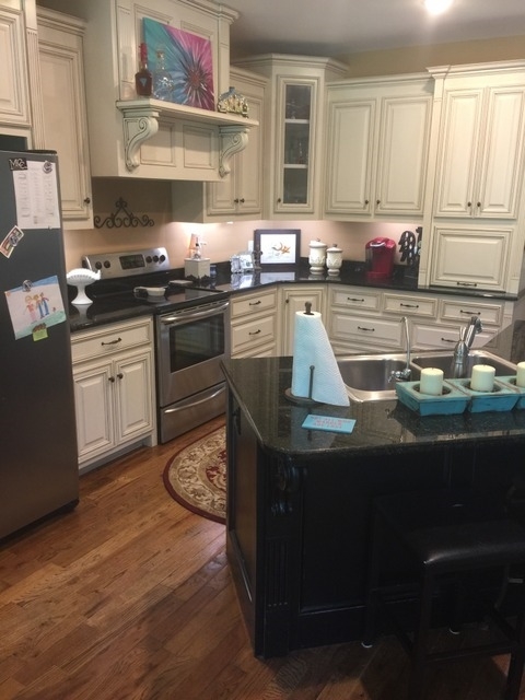 7813 Zebulon Road Macon, GA 31220 - Photo 6 of 21 a kitchen with kitchen island granite countertop a sink wooden cabinets and a granite counter tops