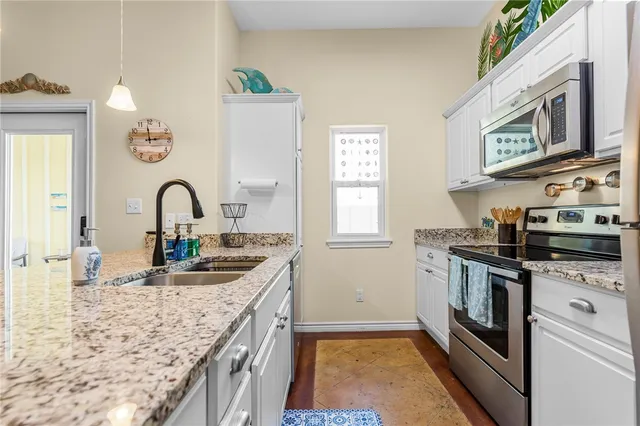 a kitchen with stainless steel appliances granite countertop a sink and stove