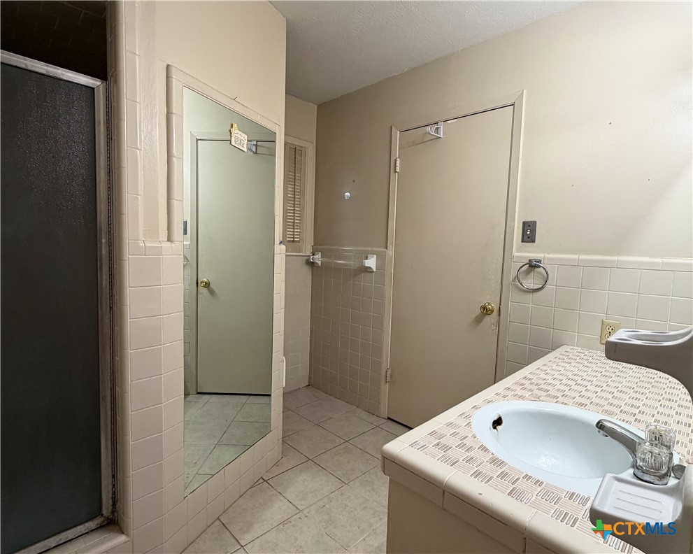2711 Forest Trail Temple, TX 76502 - Photo 14 of 22 a bathroom with a granite countertop sink a shower and a mirror