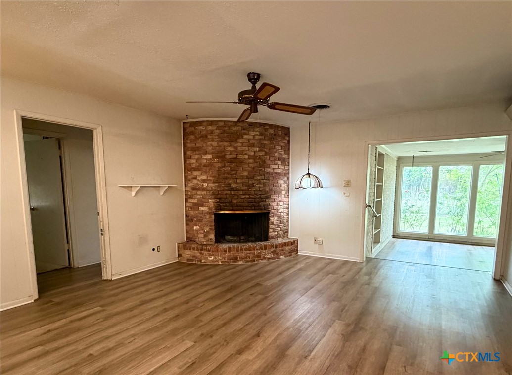 2711 Forest Trail Temple, TX 76502 - Photo 9 of 22 an empty room with wooden floor fireplace and windows