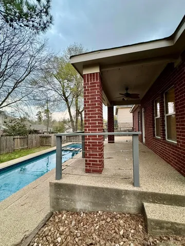 a view of swimming pool with lake and trees in the background