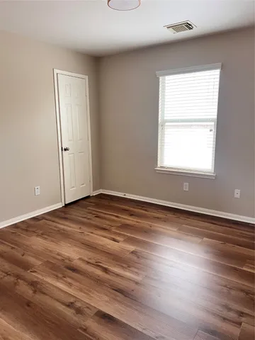 a view of a room with wooden floor and windows in it