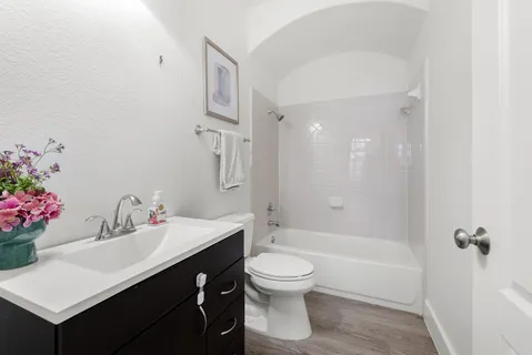 a bathroom with a sink a toilet and shower