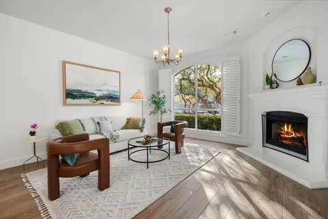 a living room with furniture a chandelier and a fireplace