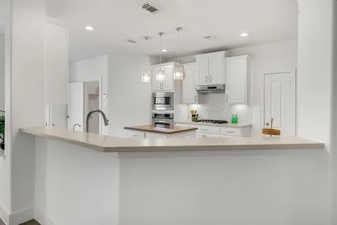 a kitchen with kitchen island a sink and cabinets
