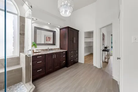 a bathroom with a granite countertop sink a mirror and a shower