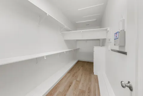 a view of walk in closet with empty racks