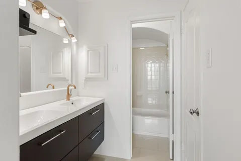 a bathroom with a double vanity sink mirror and shower